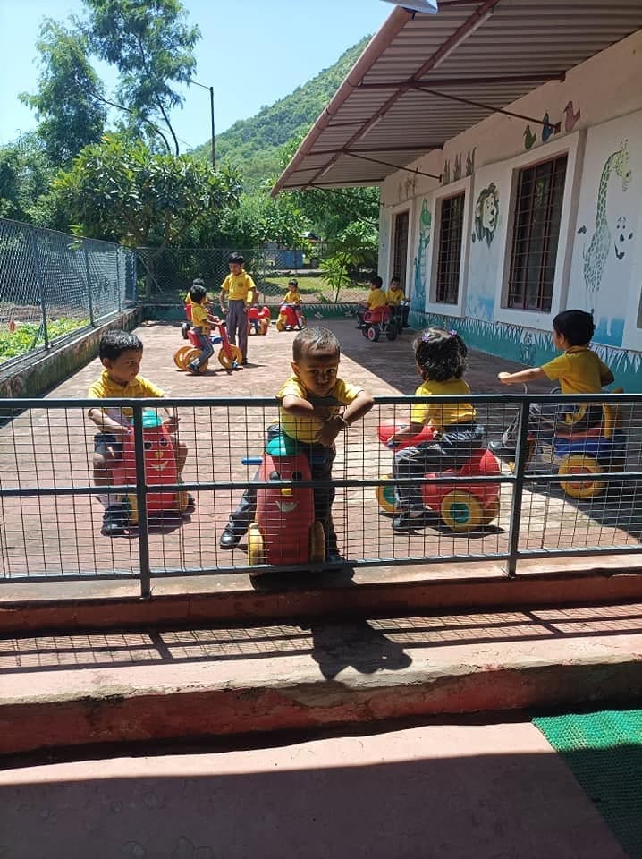 Children at play in the outdoor yard beneath the Pandavleni hills